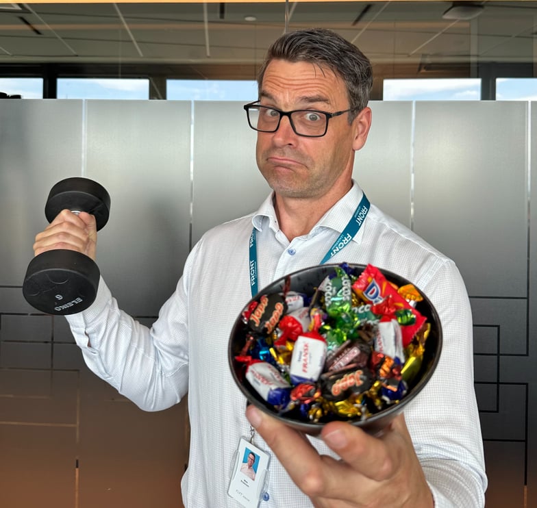 Mats Kristensen, CEO i FRONT Leadership holder en skål med twist i ene hånden og en manual i den andre