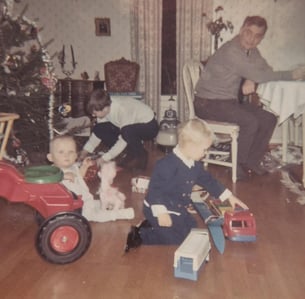 Bildet viser Gofar, onkel LillOdd, Kjerstis bror Cato og Kjersti hjemme i Smieveien 10, med juletre og barn som leker på gulvet.